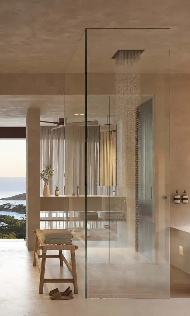 Bad mit bodengleicher Dusche, Glaswand und Meerblick