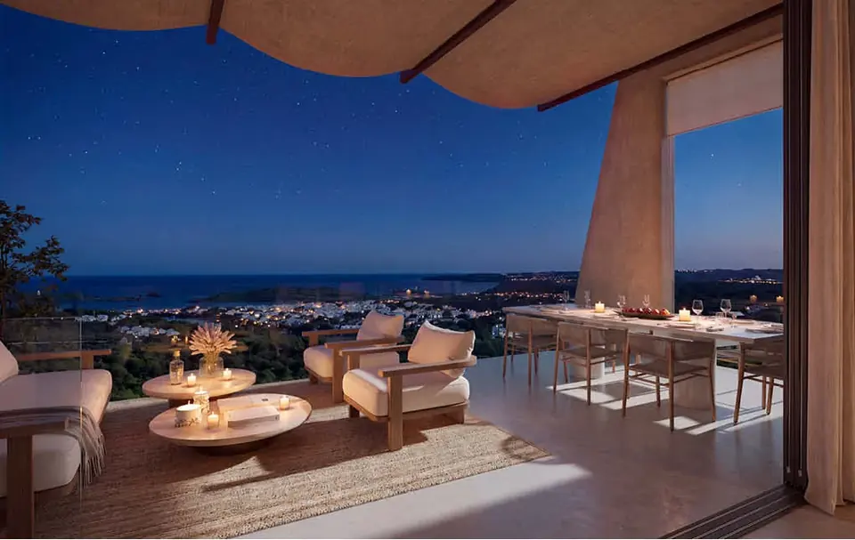 Überdachte Terrasse bei Nacht mit Lounge und Essbereich zur Bucht